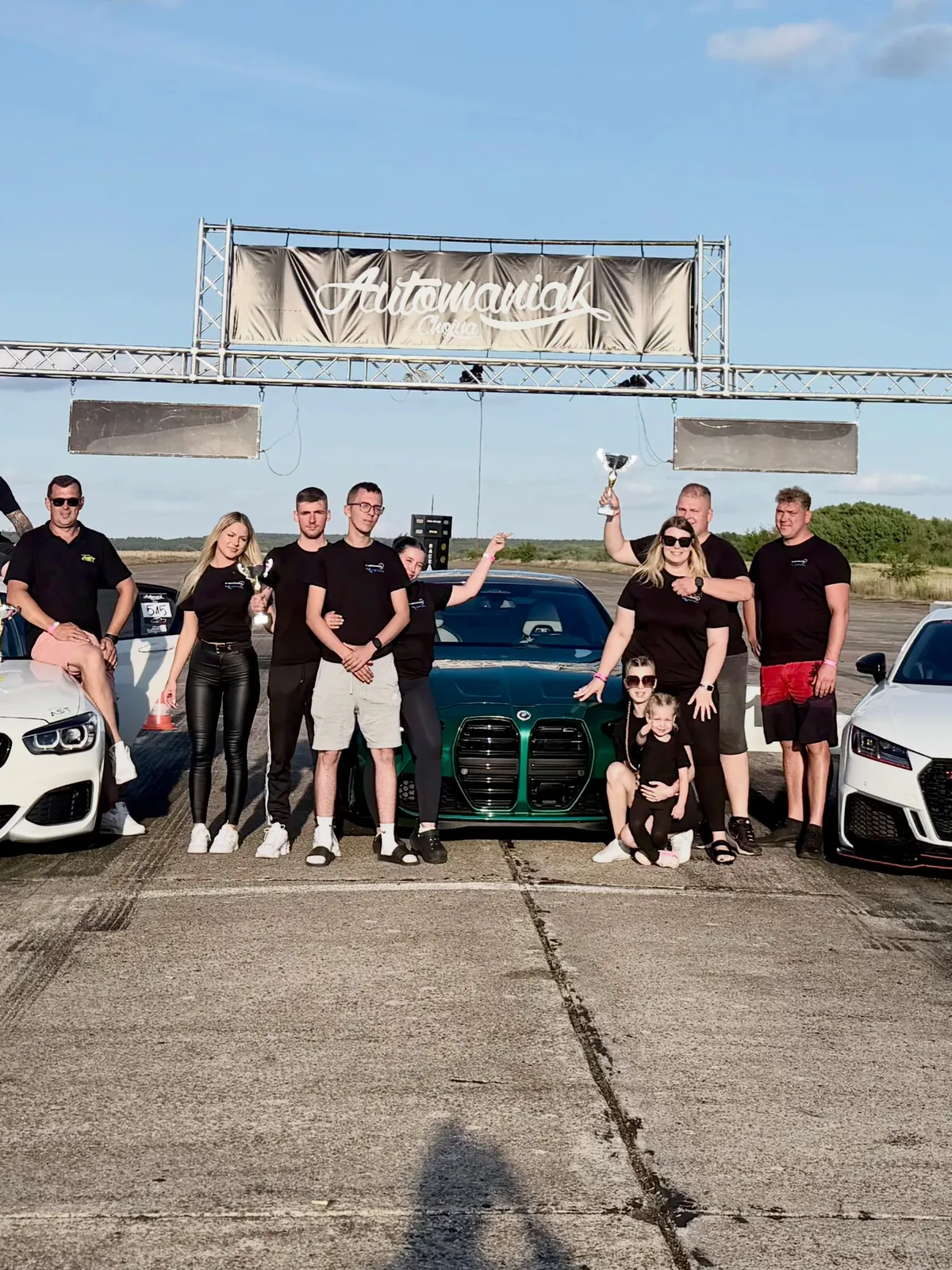The AST Performance team with their cars at the track