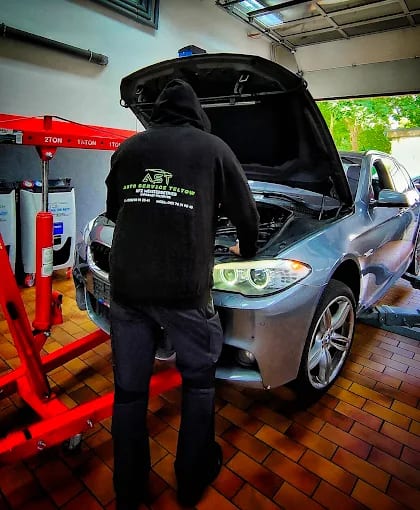 Mechaniker der AST AutoService Teltow bei der Arbeit an einem BMW in der Werkstatt